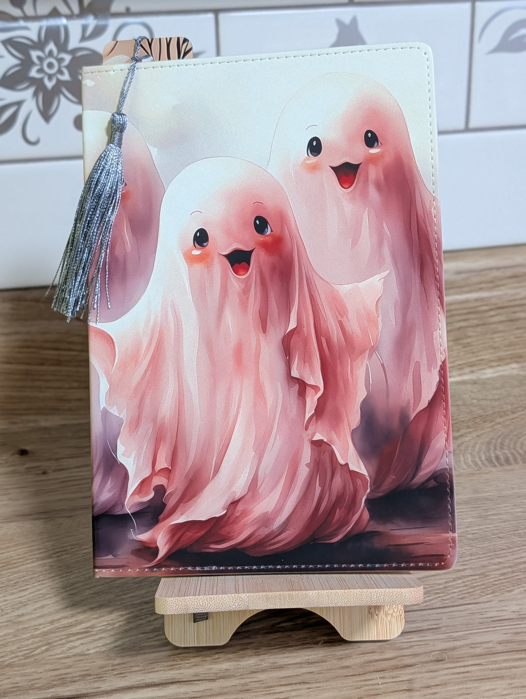 Cute ghost notebook showing two pink watercolor ghosts with silver tassel