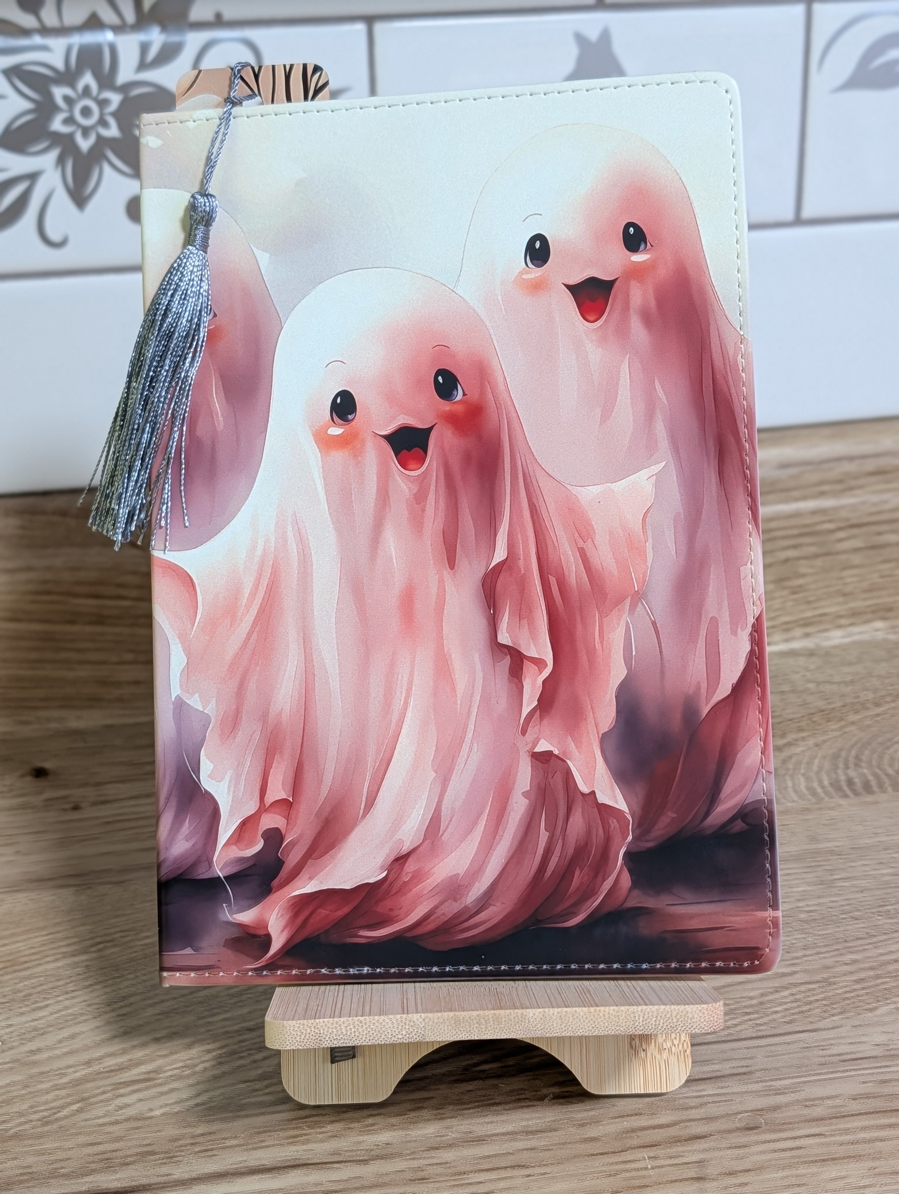 Cute ghost notebook showing two pink watercolor ghosts with silver tassel