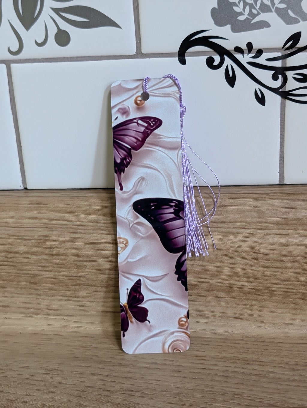 Purple butterfly bookmark back - multiple purple butterflies on white embossed floral background with pearl accents and lavender tassel