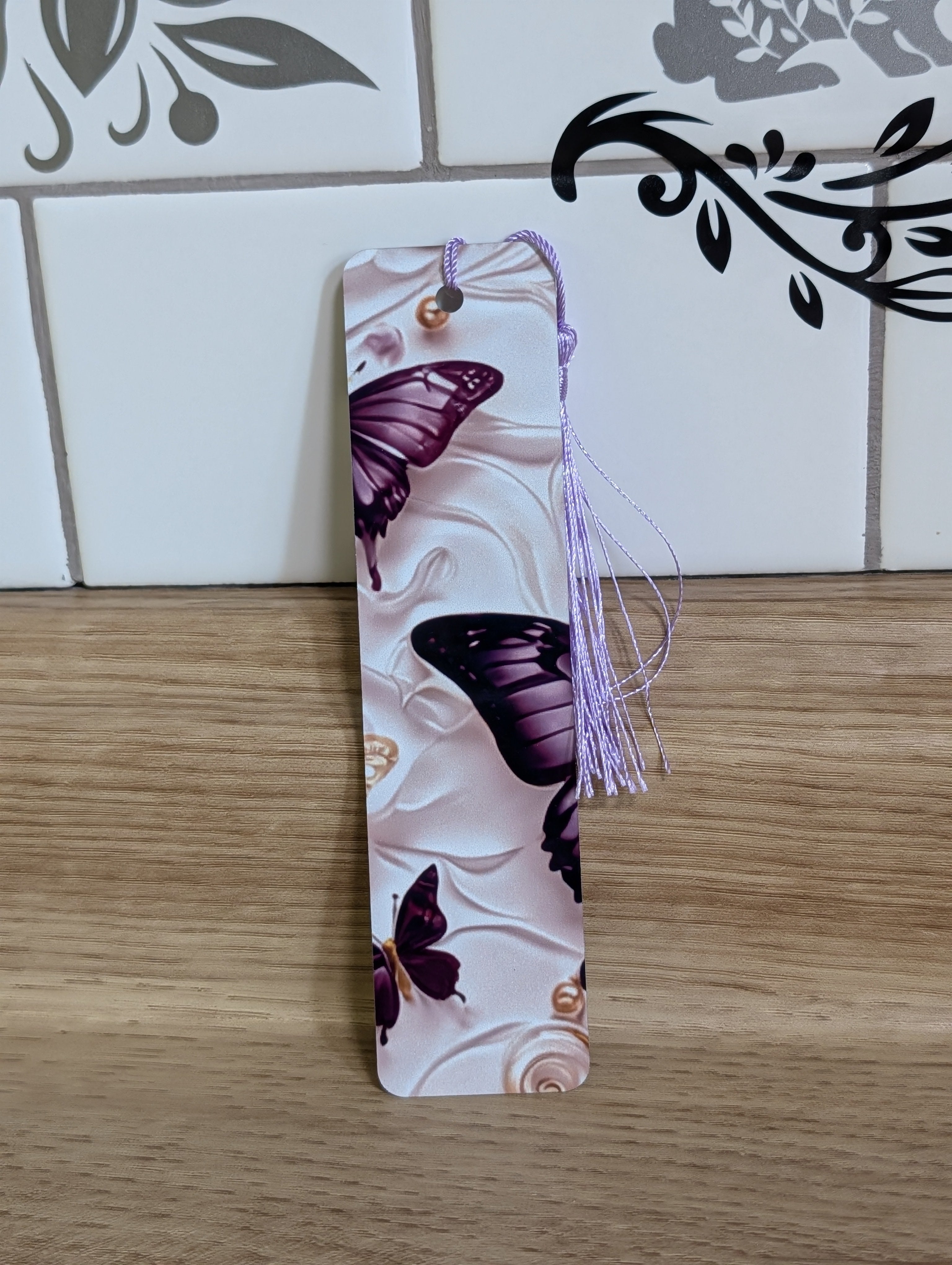 Purple butterfly bookmark back - multiple purple butterflies on white embossed floral background with pearl accents and lavender tassel