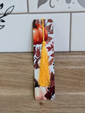 Pumpkin harvest bookmark front - white background with orange pumpkin and dark autumn leaves with yellow tassel
