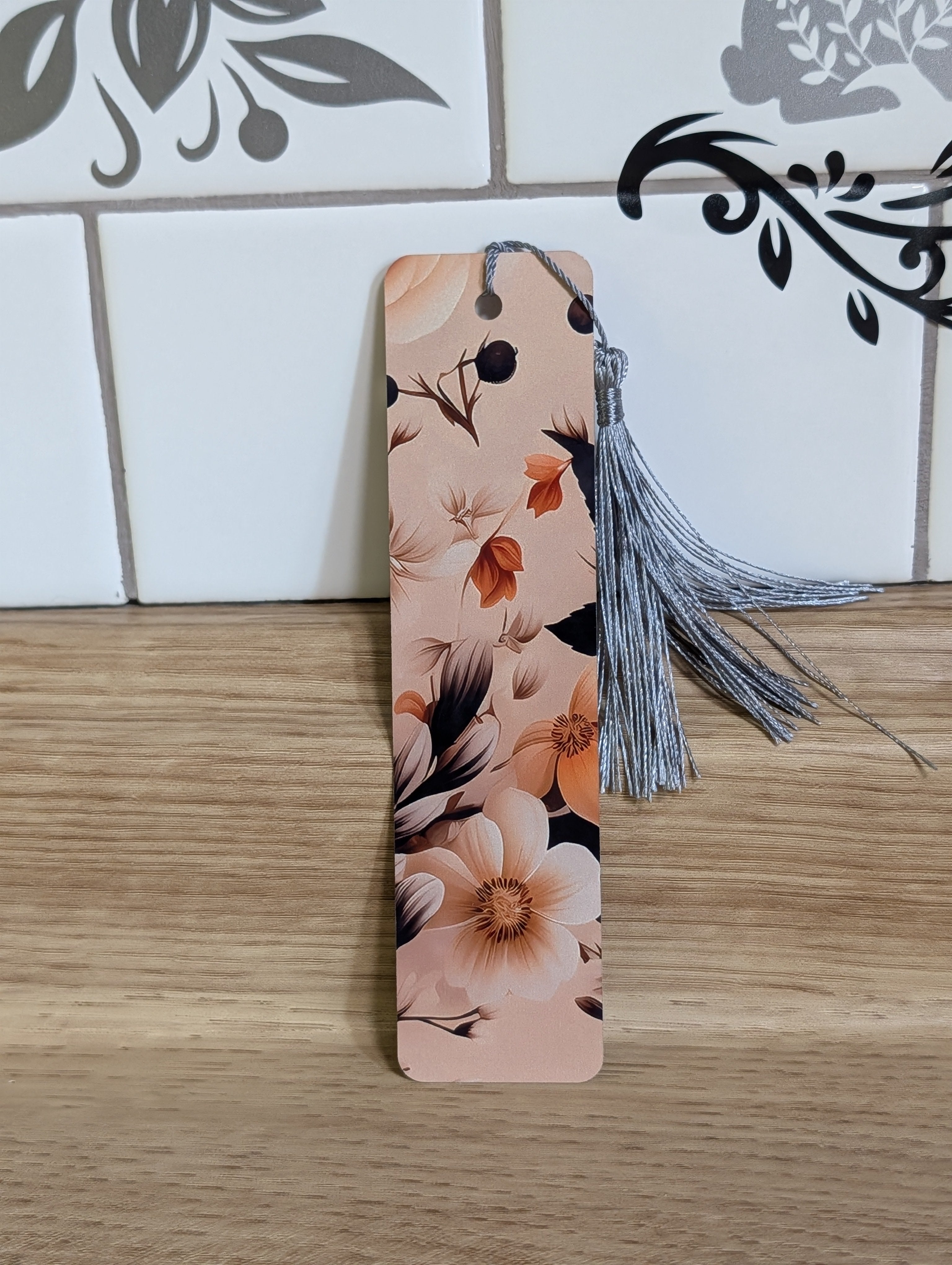 Dark floral bookmark back - blush background with large white magnolia and rust orange flowers with dark leaves and silver tassel