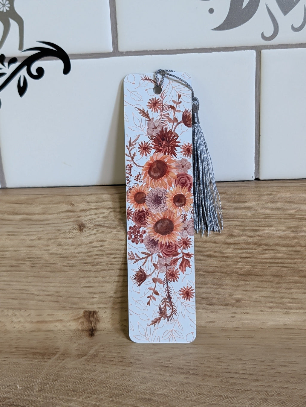 Pumpkin harvest bookmark back - white background with orange, burgundy and cream pumpkins among dark leaves with yellow tassel