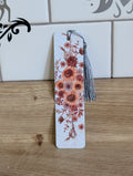 Pumpkin harvest bookmark back - white background with orange, burgundy and cream pumpkins among dark leaves with yellow tassel