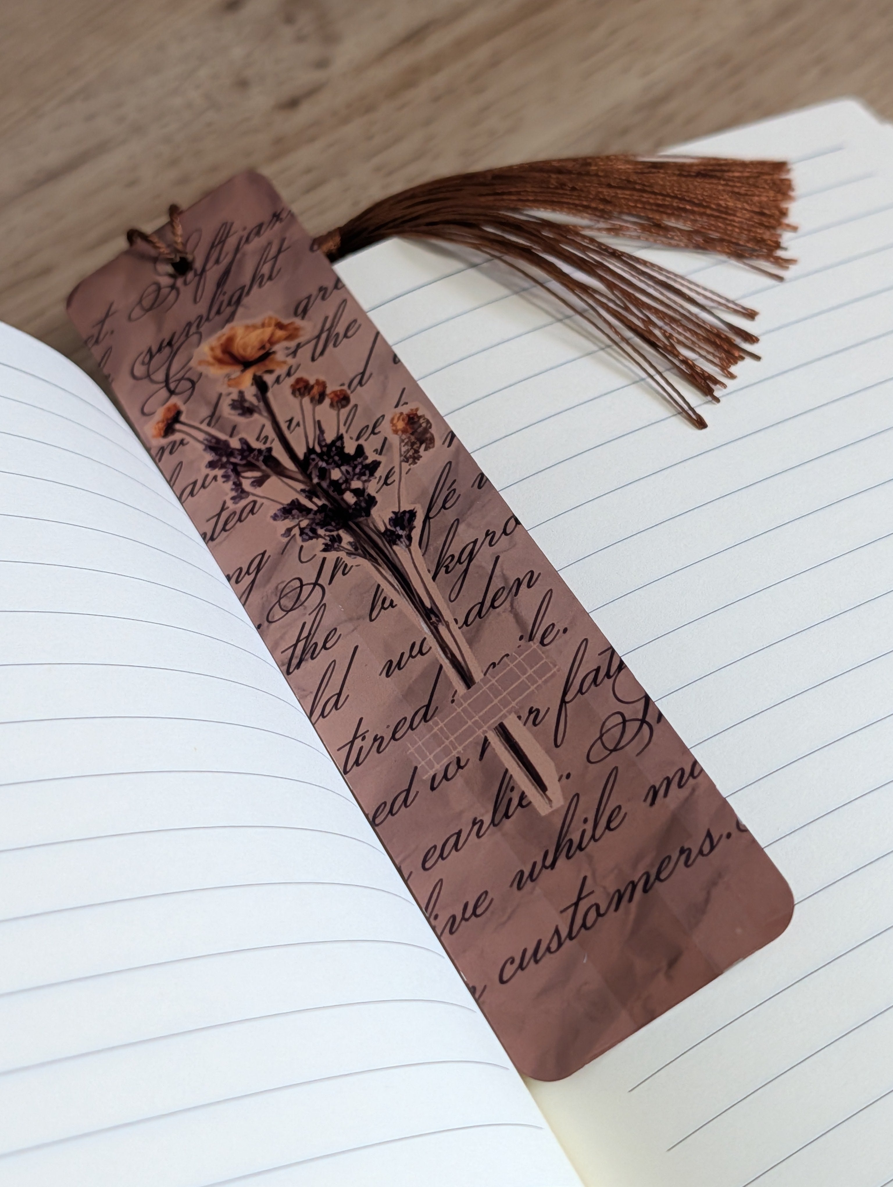 Scrapbook botanical bookmark tucked in journal pages with brown tassel